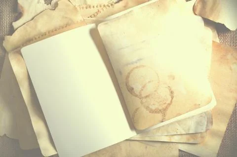 Stack old papers and notebook on burlap, sackcloth background. Vintage and retro Stock Photos
