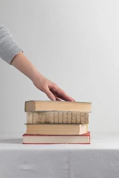 Stack of old rustic vintage books with the hand Foto stock