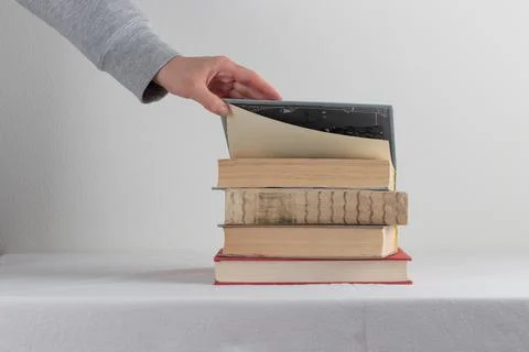 Stack of old rustic vintage books with the hand Foto stock