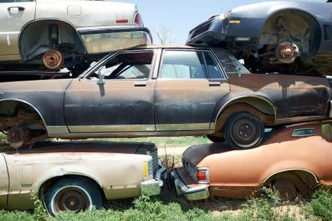 Stack of old rusting cars in a breakers yard Foto stock