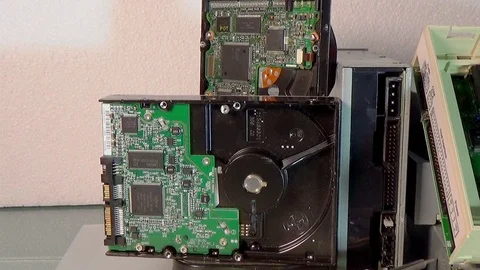 Stack of old SATA, ATA hard disk drives and driver cd disassembled. Stock-Footage 106501974