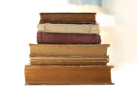 A stack of old tattered books on a white background. Pyramid of old books in Stock-Fotos