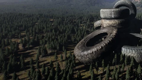 Stack of old tires in a forest near mountain range during daylight Stock Footage 343539080