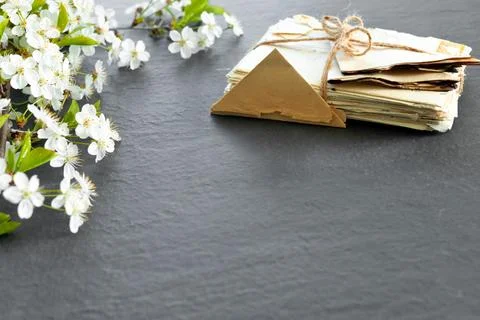 Stack of old torn vintage letters on yellowed paper against black granite t.. 스톡 사진