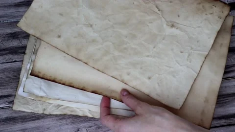A stack of old vintage paper is going through a woman's hands. Stock Footage 195934391