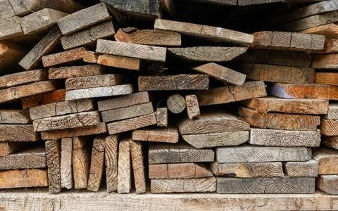 Stack of old wooden boards and firewood neatly piled outdoors for winter he.. Stock Photos