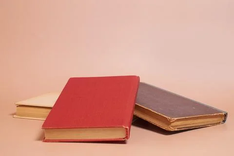 A stack of old worn books on a colored background Stock Photos