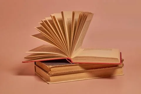 A stack of old worn books on a colored background Stock Photos