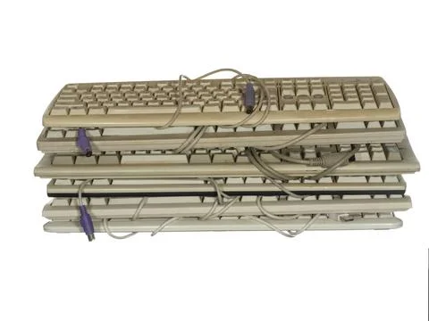 Stack of old worn keyboards isolated on white background. Foto stock