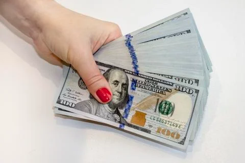 Stack of one hundred dollar banknotes in hand Stock Photos