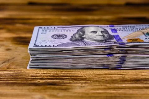 Stack of the one hundred dollar banknotes on wooden background Stock Photos