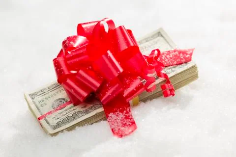 Stack of One Hundred Dollar Bills with Red Ribbon on Snow Flakes. Stock Photos