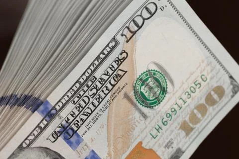 Stack of one hundred dollar bills on a wooden table Stock Photos