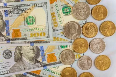 Stack of one hundred dollar bills with US one dollar coins on close-up. Stock Photos