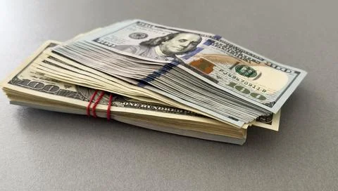 A stack of one hundred dollar bills on a background of dollars Foto stock