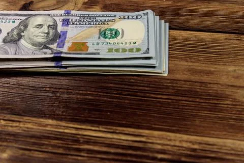 Stack of one hundred dollars bills on wooden desk 스톡 사진