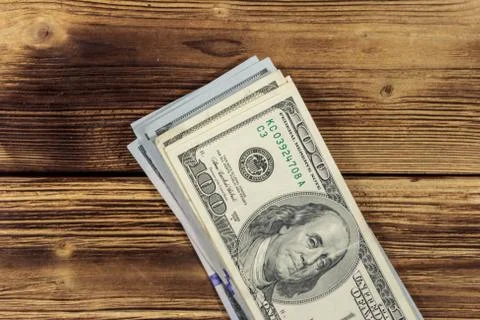 Stack of one hundred dollars bills on wooden desk 스톡 사진
