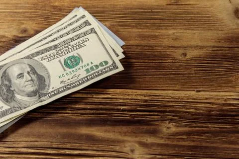 Stack of one hundred dollars bills on wooden desk 스톡 사진