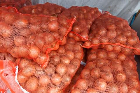 Stack of onion sacks in grocery store Foto stock