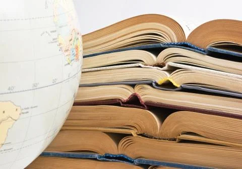 Stack of open books and globe Foto stock