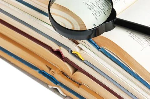 Stack of open books, and magnifier 스톡 사진
