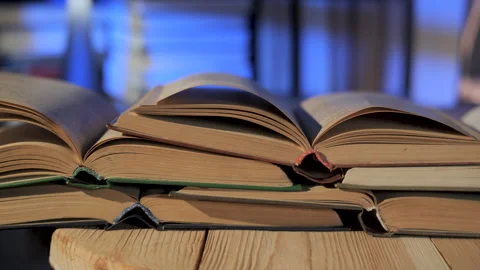 Stack of open books forming layered pages in quiet reading environment Stock Footage 334314532