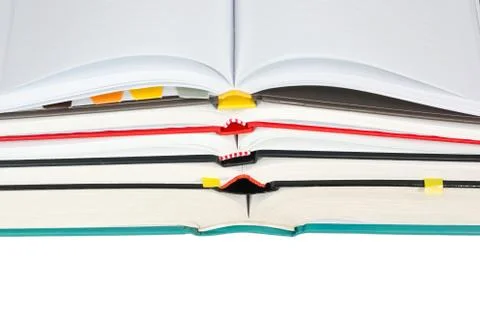 Stack of open books with notebook on top isolated on white background Stock Photos