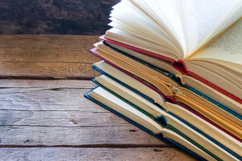 Stack of open books on a wooden background and space for text 스톡 사진