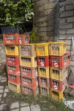 Stack of orange and yellow crates with Coca Cola bottles on top Stock Photos