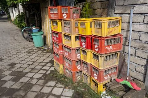 Stack of orange and yellow crates with Coca Cola bottles on top Stock Photos