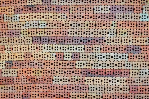 Stack of orange bricks in construction site with brick wall texture background Stock Photos