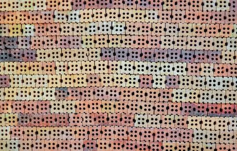 Stack of orange bricks in construction site with brick wall texture background Stock Photos
