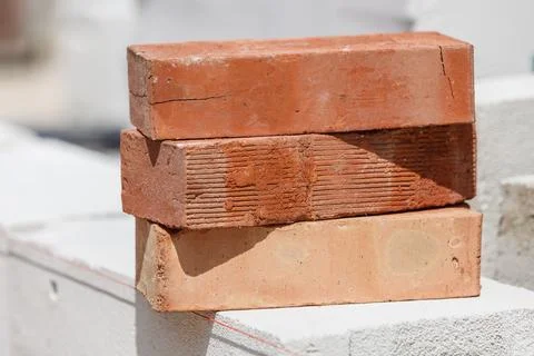 Stack of orange bricks on construction site Stock Photos