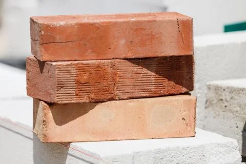 Stack of orange bricks on construction site Stock Photos