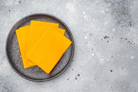Stack of orange cheese slices on round plate minimal food composition with .. Stock-Fotos