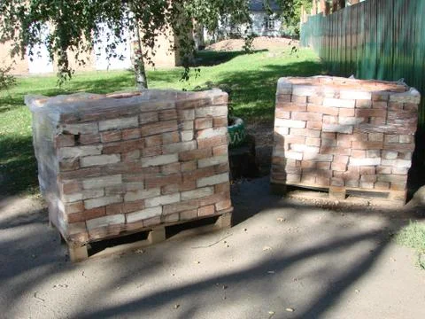 Stack of orange clay brick on pallet Stock Photos