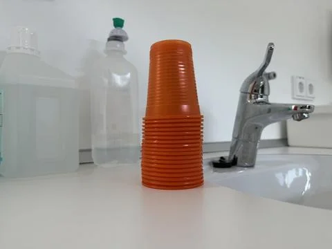 Stack of Orange Dental Plastic Cups on Countertop Stock Photos