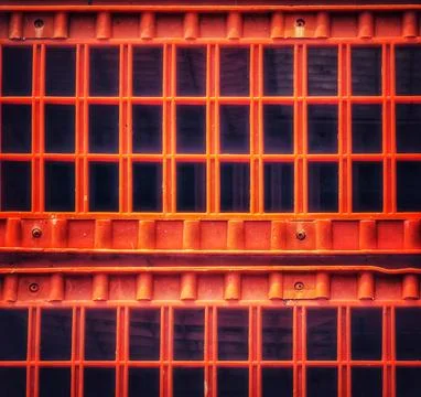 Stack of orange plastic crates shows a geometric grate pattern with repeating Stock Photos