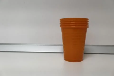 Stack of Orange Plastic Cups on White Surface 库存照片