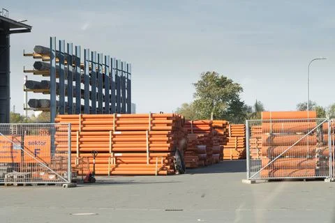 Stack of orange plastic sewage pipes used at the building site 스톡 사진