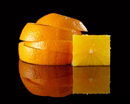 A stack of orange slices and a cube of fruit flesh Stockfoto's
