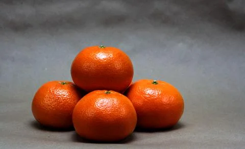 Stack of orange tangerines resting on a paper bag surface Stock Photos