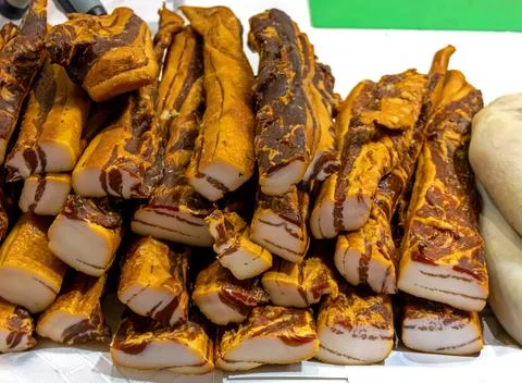 Stack of organic homemade cured pork bacon sold outside on local market Stock Photos