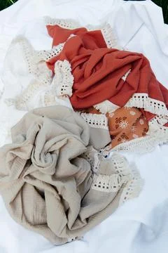 Stack of organic muslin cotton blankets in assorted earthy colors: terracotta, Stock Photos