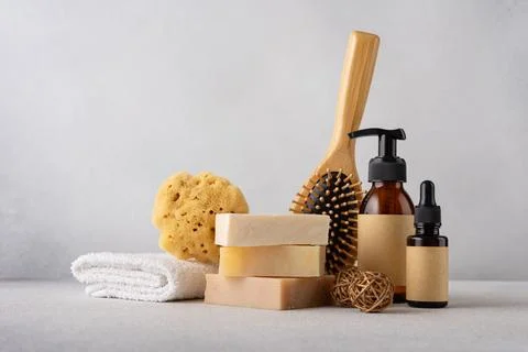 Stack of organic soap bars, bamboo hair comb, cosmetic bottles, natural spong Stock Photos