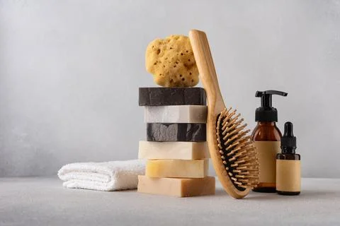 Stack of organic soap bars, bamboo hair comb, cosmetic bottles, natural spong 写真素材