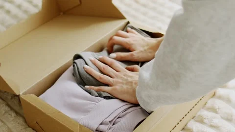 Stack organizing second-hand clothing for sorting recycling Видео 331459957