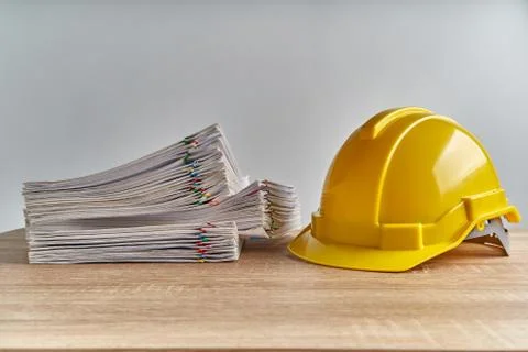 Stack overload document of report with yellow engineer hat Stock Photos