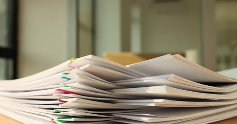 Stack of overloaded document paper with colorful paper clip on table Stock Footage 234127401