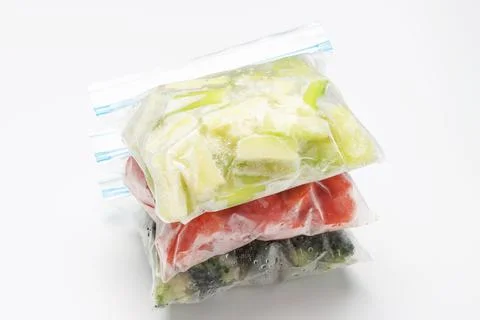 A stack of packages of frozen vegetables on white background close-up 스톡 사진